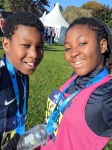 Thando and her brother with their run medals on, both smiling