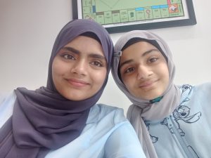 Nivisha and another young woman, smiling at the camera