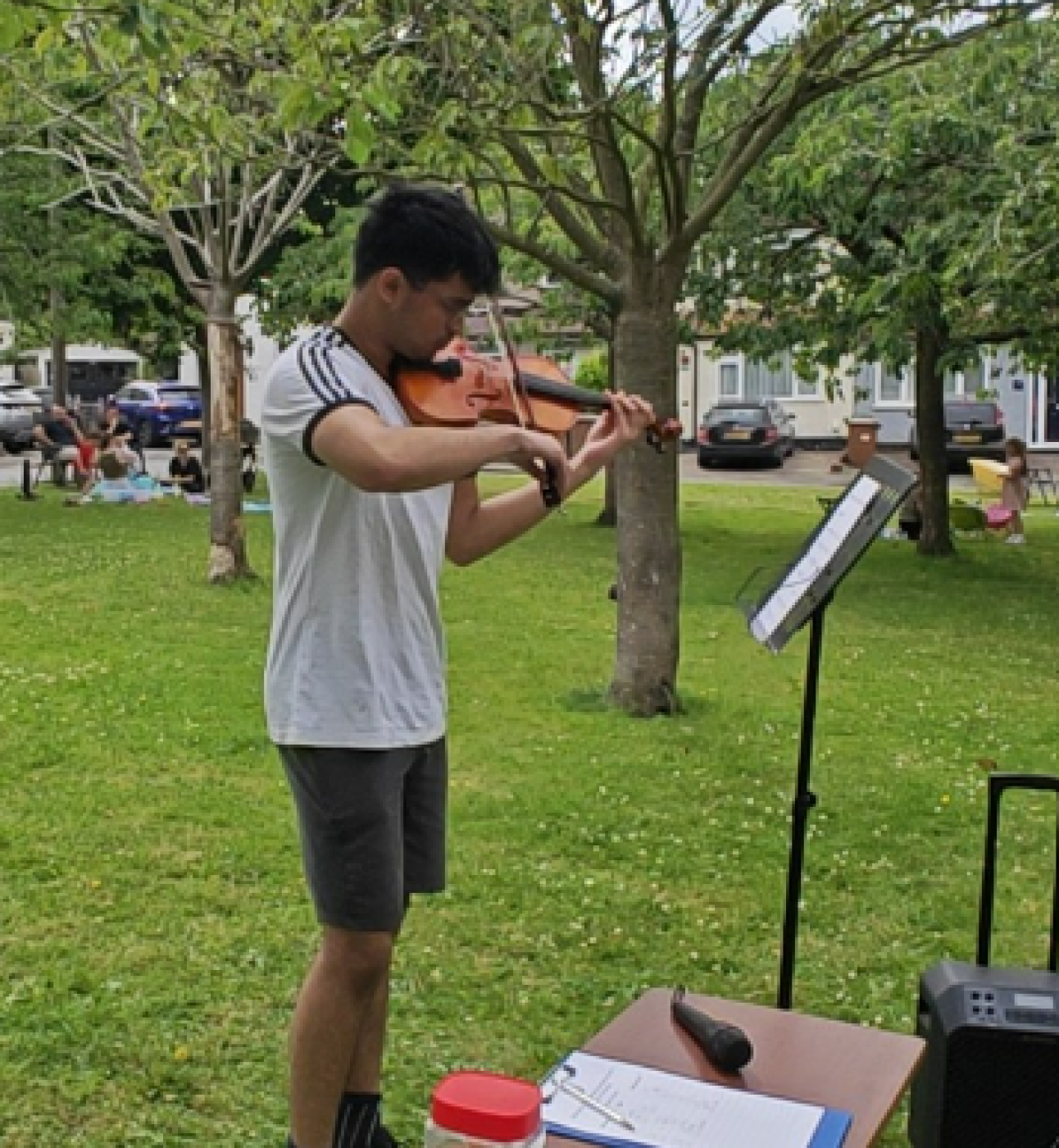 Poorwa playing the violin outside in a field