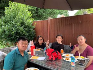 Rosie's friends and family sat outside at the table, eating and giving a thumbs up