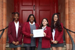 A group of four students holding an RMBF certificate