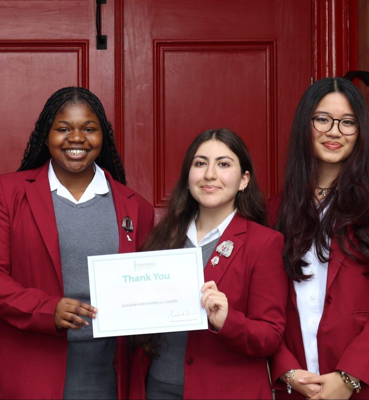 Four students holding an RMBF certificate and smiling