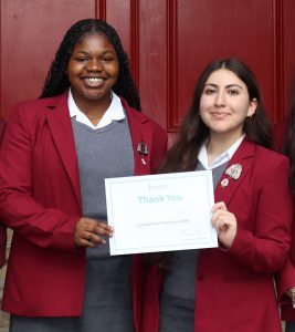 Two female students holding an RMBF certificate, smiling at the camera