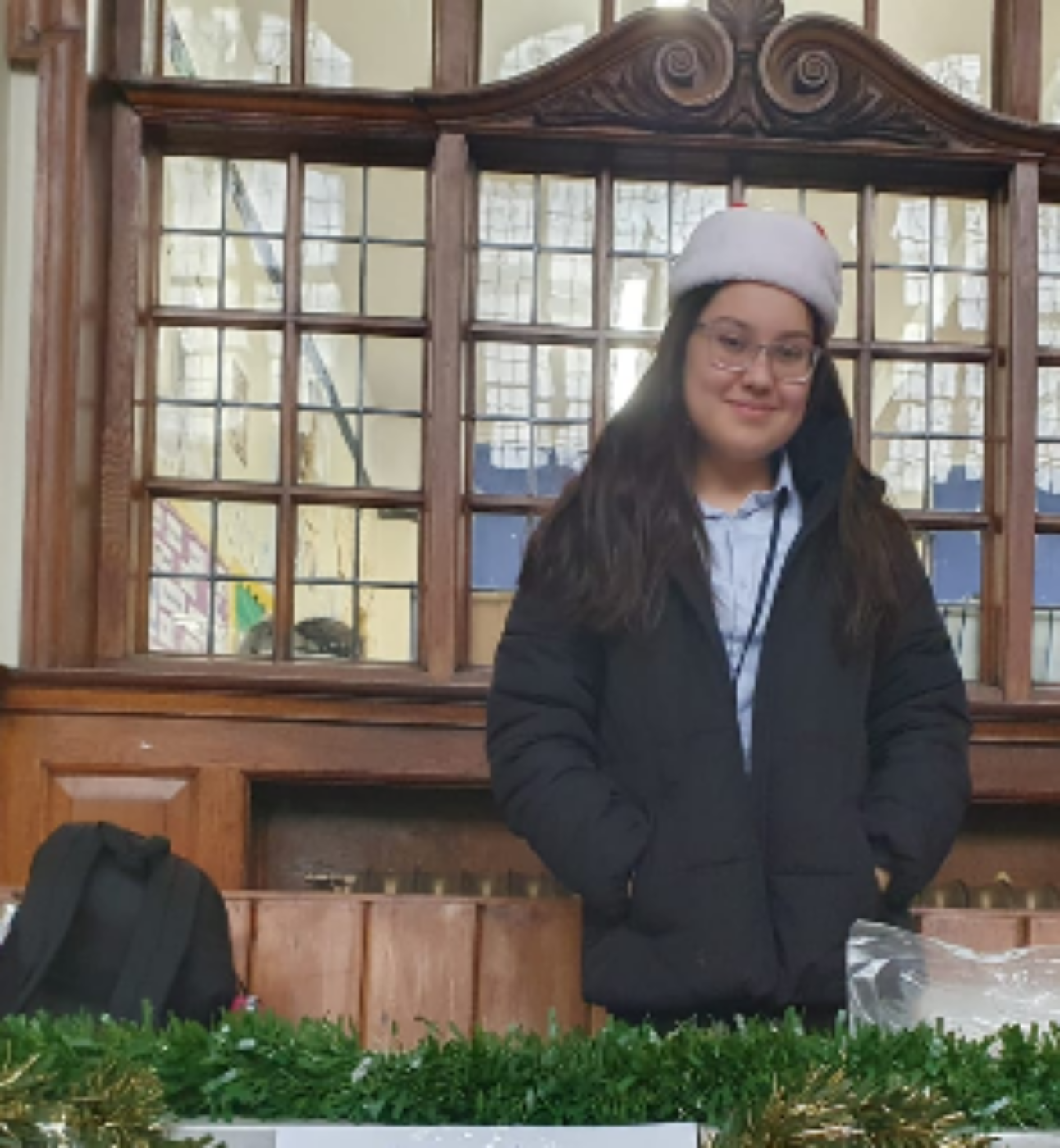Sophie, stood smiling behind a table decorated with tinsel
