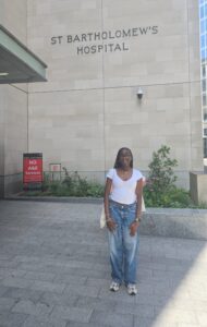 Michelle, smiling and standing in front of St Bartholomew's Hospital