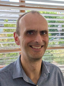 A photograph of CEO Mark Williams. He is a white man with close cropped hair, wearing a shirt and smiling.